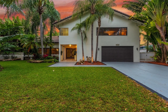 mediterranean / spanish home with a lawn and a garage