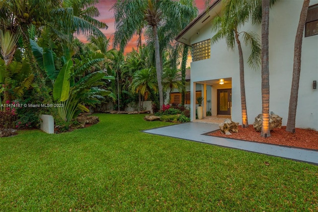 yard at dusk with a patio area