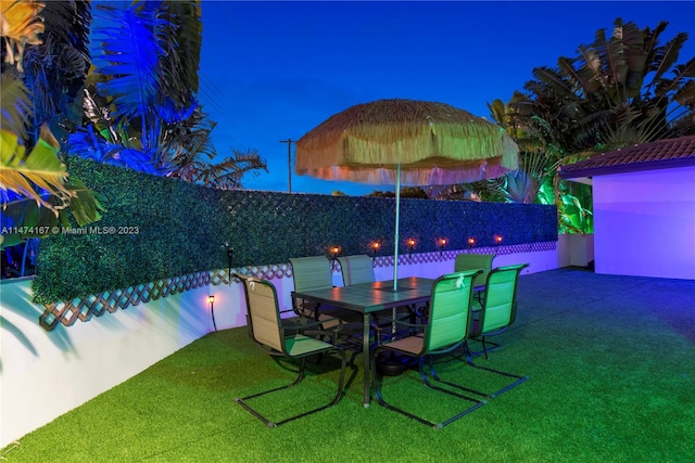 patio terrace at night featuring a lawn