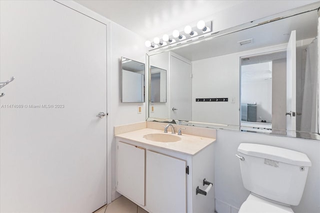 bathroom featuring toilet, tile floors, and large vanity