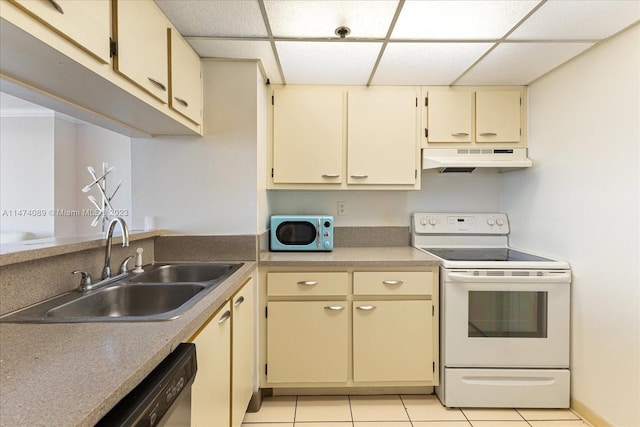 kitchen featuring sink, light tile floors, appliances with stainless steel finishes, a paneled ceiling, and cream cabinets