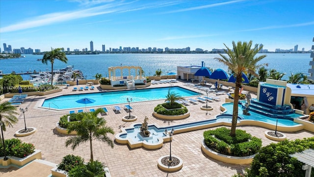 view of swimming pool with a patio and a water view