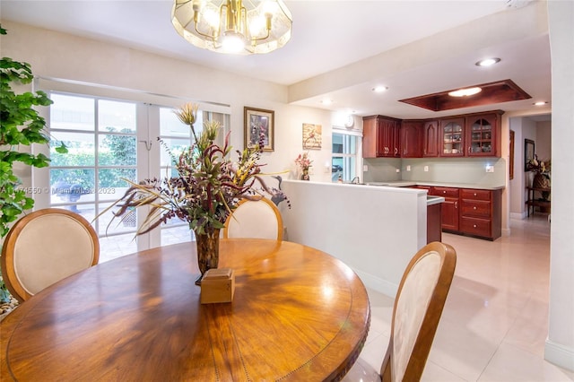 19720 SW 242nd Ter, Homestead, FL 33031 - tiled dining area featuring a notable chandelier, a tray ceiling, and french doors