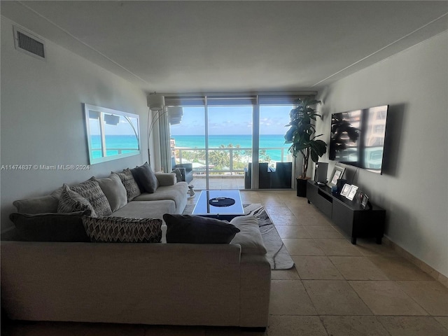 living room with a water view and light tile flooring