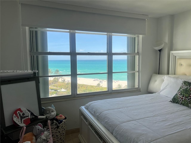 bedroom with a water view and multiple windows