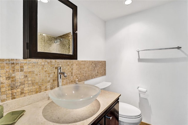 bathroom featuring vanity, backsplash, and toilet