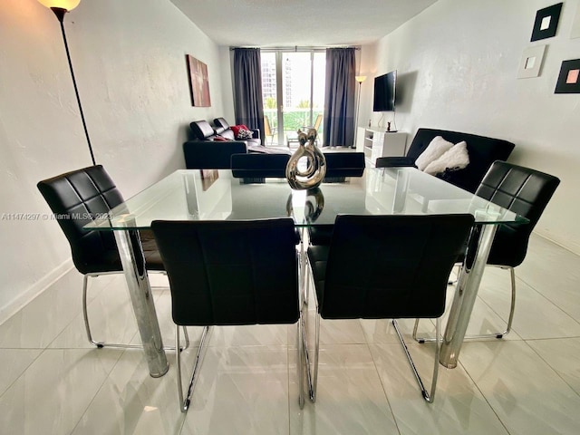 tiled dining room with floor to ceiling windows