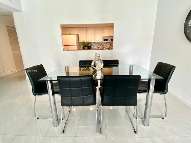 dining space featuring light tile flooring