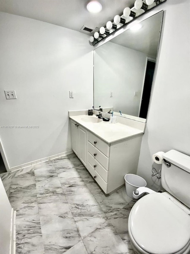 bathroom featuring toilet, tile floors, and vanity