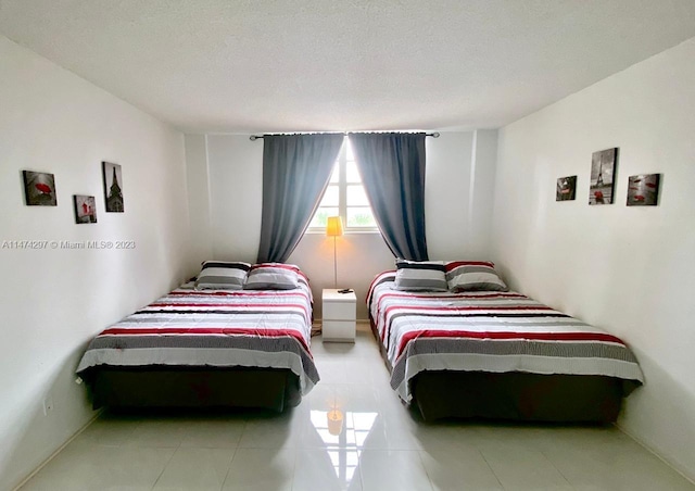 tiled bedroom with a textured ceiling