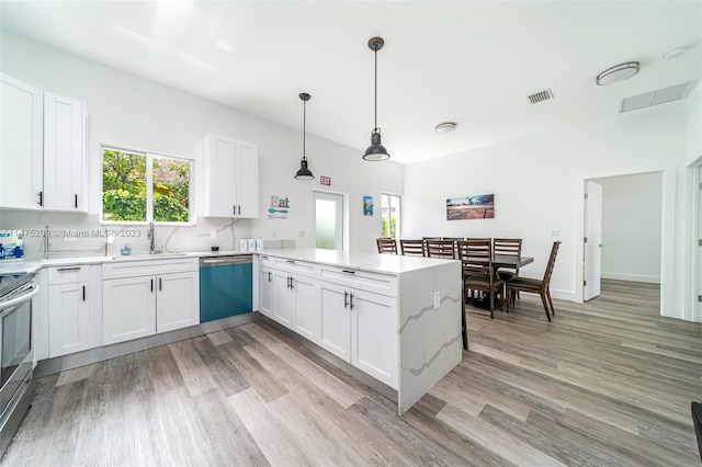 kitchen featuring appliances with stainless steel finishes, decorative light fixtures, white cabinetry, and light hardwood / wood-style flooring