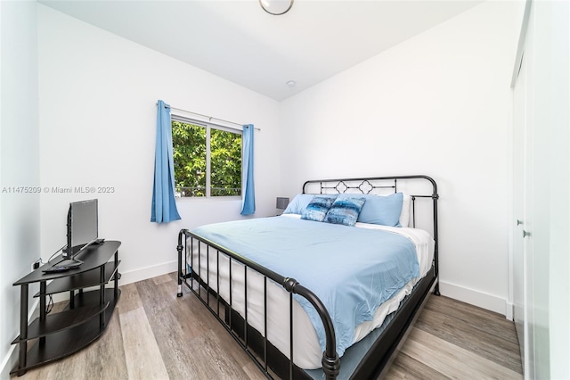 bedroom featuring lofted ceiling and light hardwood / wood-style flooring