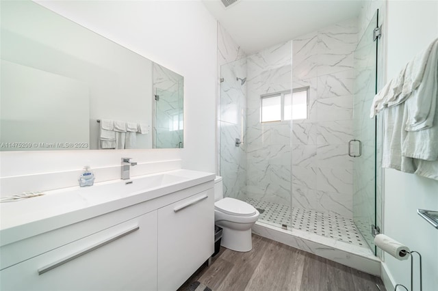 bathroom featuring walk in shower, toilet, hardwood / wood-style floors, and oversized vanity