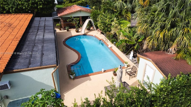 view of swimming pool featuring a patio and a water slide