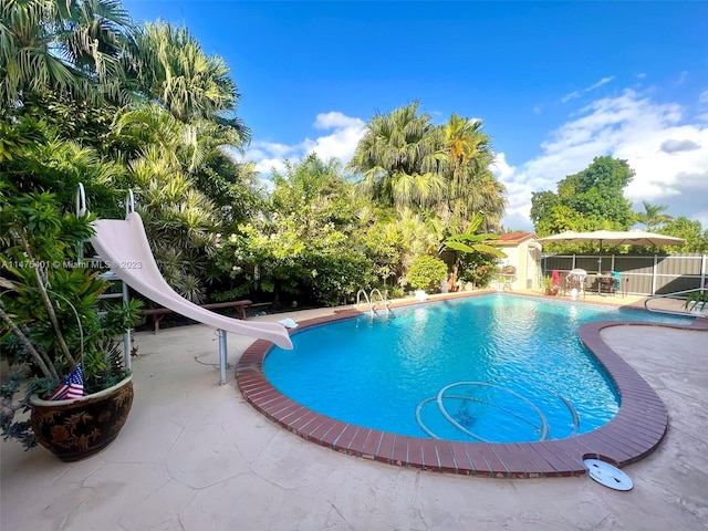 view of swimming pool with a patio area and a water slide