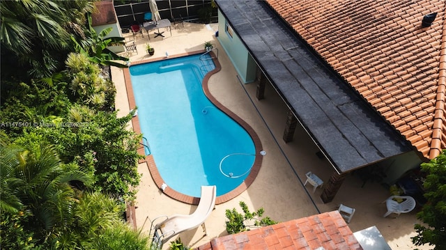 view of pool with a water slide and a patio