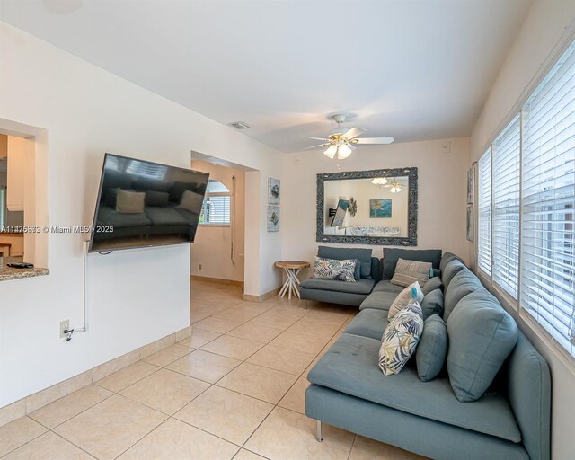 tiled living room with a healthy amount of sunlight and ceiling fan