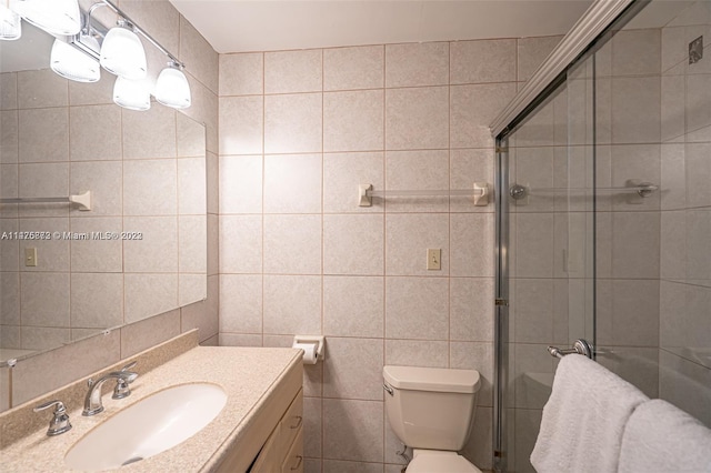 bathroom featuring tile walls, vanity with extensive cabinet space, and toilet