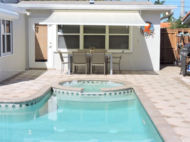 view of pool featuring area for grilling, a patio area, and an in ground hot tub