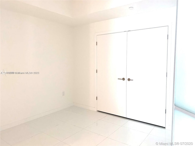 unfurnished bedroom with a closet and light tile floors