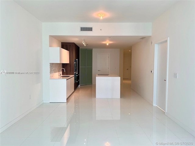 tiled empty room featuring sink