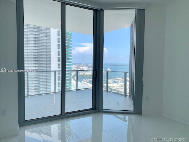 entryway featuring light tile floors, expansive windows, and a water view