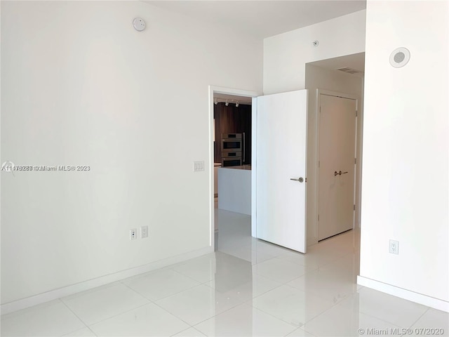 unfurnished room featuring light tile floors