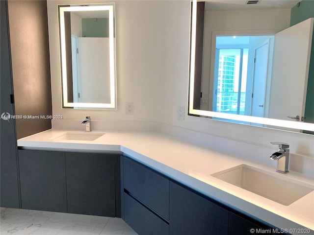 bathroom with tile floors, large vanity, and double sink