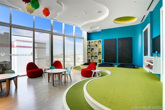 recreation room with expansive windows and light hardwood / wood-style floors