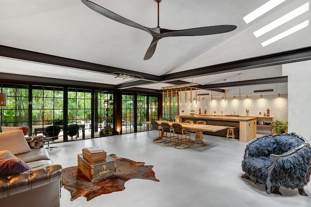 living room with lofted ceiling with skylight, concrete floors, and ceiling fan