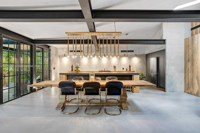 dining room with concrete flooring, coffered ceiling, beam ceiling, and bar