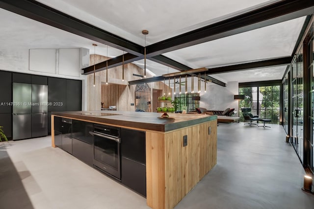 kitchen featuring hanging light fixtures, a center island, black appliances, and beam ceiling