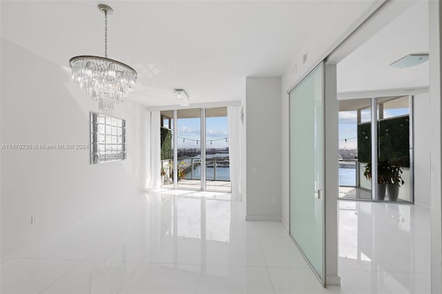 tiled spare room with an inviting chandelier