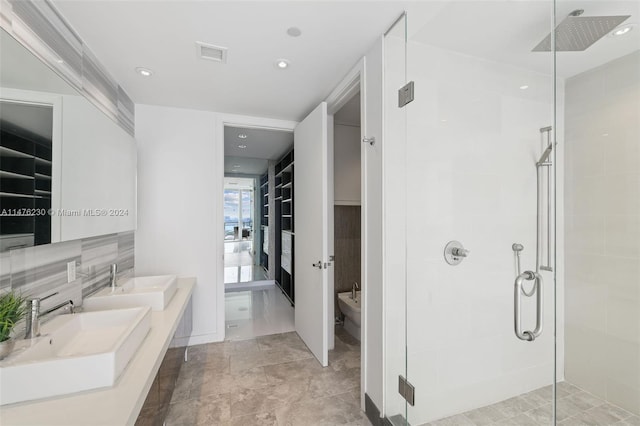 bathroom featuring vanity with extensive cabinet space, a bidet, a shower with door, dual sinks, and tile flooring