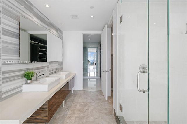 bathroom featuring backsplash, tile flooring, dual vanity, and an enclosed shower