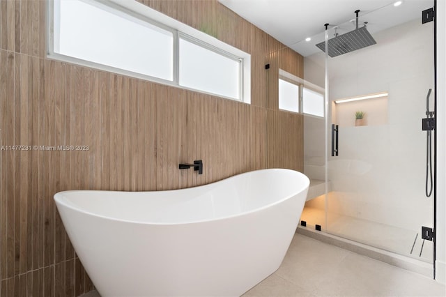 bathroom with tile walls, tile patterned floors, and independent shower and bath