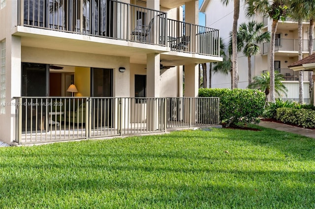 back of property with a balcony and a lawn