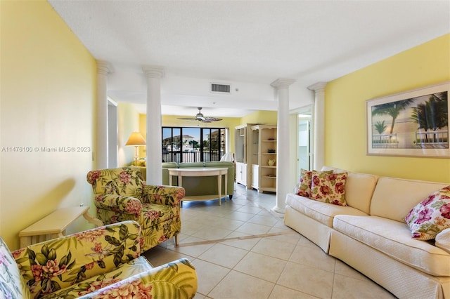 living room featuring light tile flooring, ceiling fan, and ornate columns