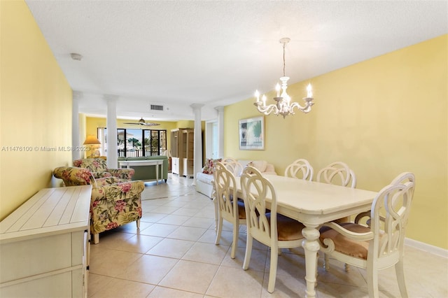 dining room featuring decorative columns, light tile floors, a textured ceiling, and ceiling fan with notable chandelier