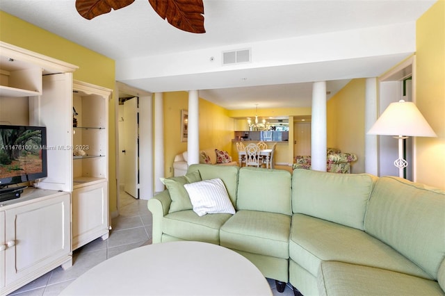 tiled living room featuring ceiling fan with notable chandelier