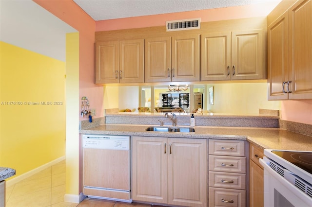 kitchen featuring light tile floors, sink, light brown cabinetry, and dishwashing machine