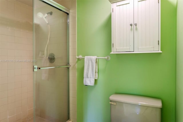 bathroom with toilet and a shower with shower door