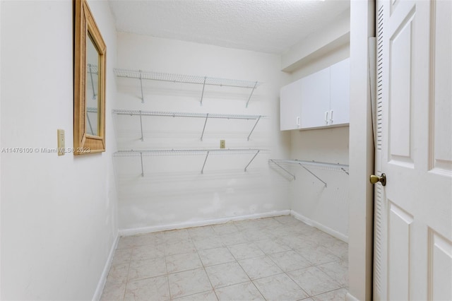 spacious closet with light tile floors