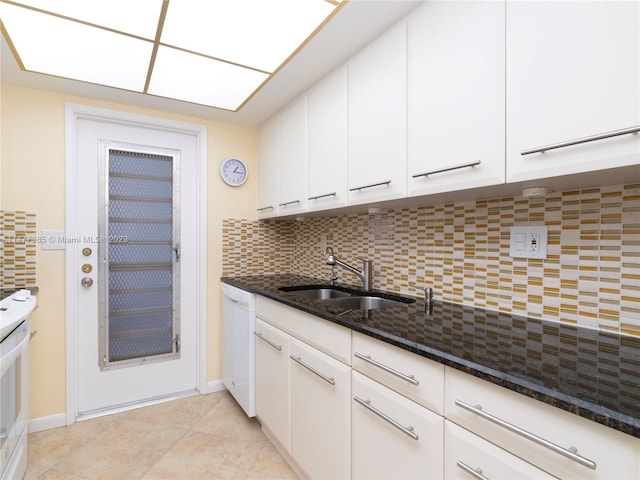 kitchen featuring white cabinetry, backsplash, sink, dark stone counters, and dishwasher