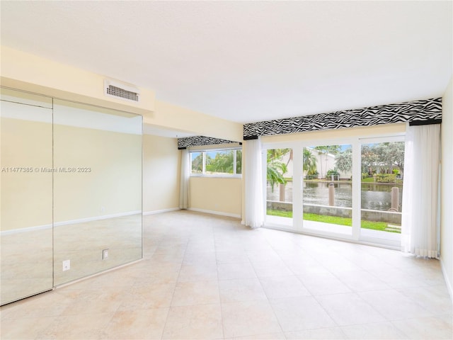 tiled spare room with a water view