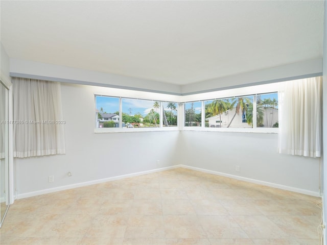 tiled spare room featuring a wealth of natural light