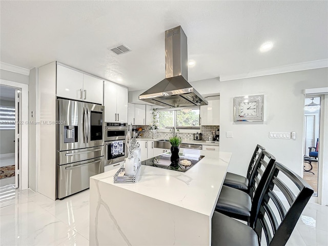 kitchen with stainless steel appliances, light tile floors, tasteful backsplash, white cabinetry, and island exhaust hood