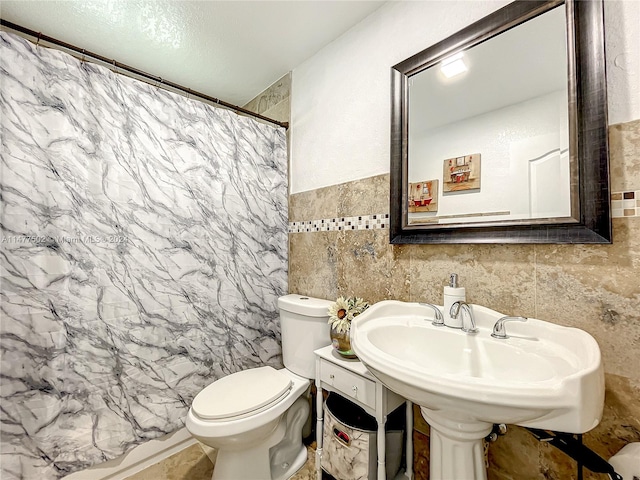 bathroom featuring tile walls, tile floors, and toilet