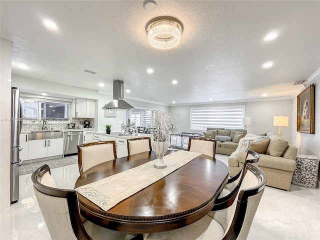 tiled dining room featuring an inviting chandelier, a textured ceiling, and sink