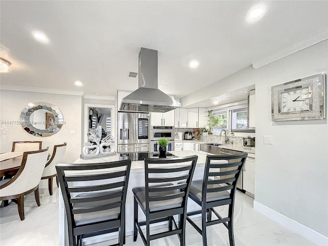 tiled dining room with sink and ornamental molding